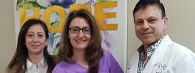 Doctors posing for a picture with happy patient, ON